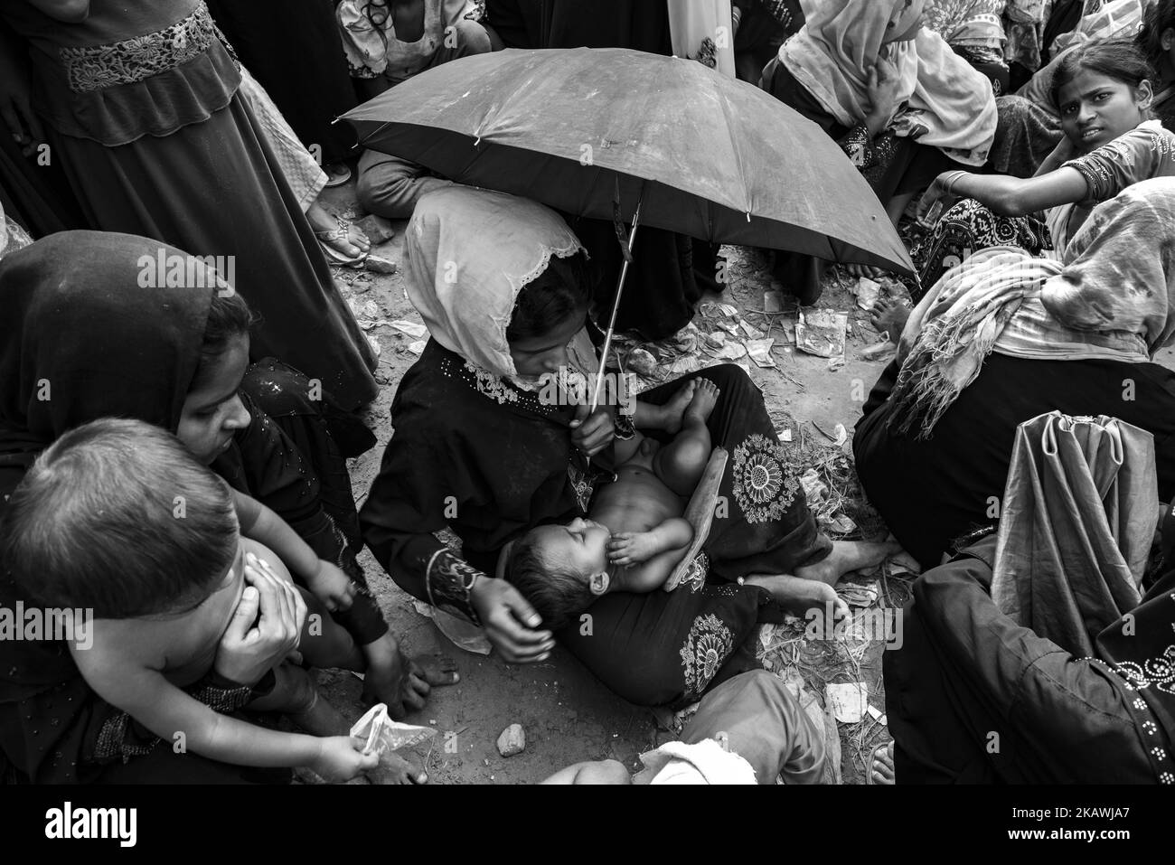 Une réfugiée de Rohingya avec son jeune enfant et d'autres attend de recevoir une aide alimentaire d'une ONG locale au camp de réfugiés de Balukhali près de Cox's Bazar, au Bangladesh, au 22 novembre 2017. (Photo de Szymon Barylski/NurPhoto) Banque D'Images