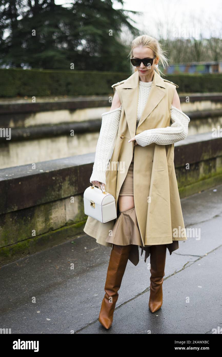Tatiana Korsakova porte un trench-coat beige sans manches, des bottes  brunes, un sac, une laine blanche à l'extérieur de Valentino, pendant la  semaine de la mode de Paris vêtements pour femmes automne/hiver