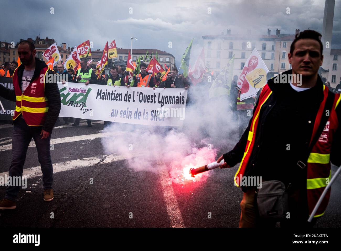 Des manifestants d'employés de la SNCF ont mis une bannière à l'affiche et ont déclenché des éruptions lors d'une manifestation organisée par des cheminots et d'autres syndicats à Lyon, en France, sur 4 avril 2018. Les trains et les avions ont été annulés à travers la France, alors que les syndicats ont poussé vers l'avant, avec des protestations contre le président Emmanuel Macrons, qui prévoyait de retirer les avantages de certains travailleurs de l'État. (Photo de Nicolas Liponne/NurPhoto) Banque D'Images