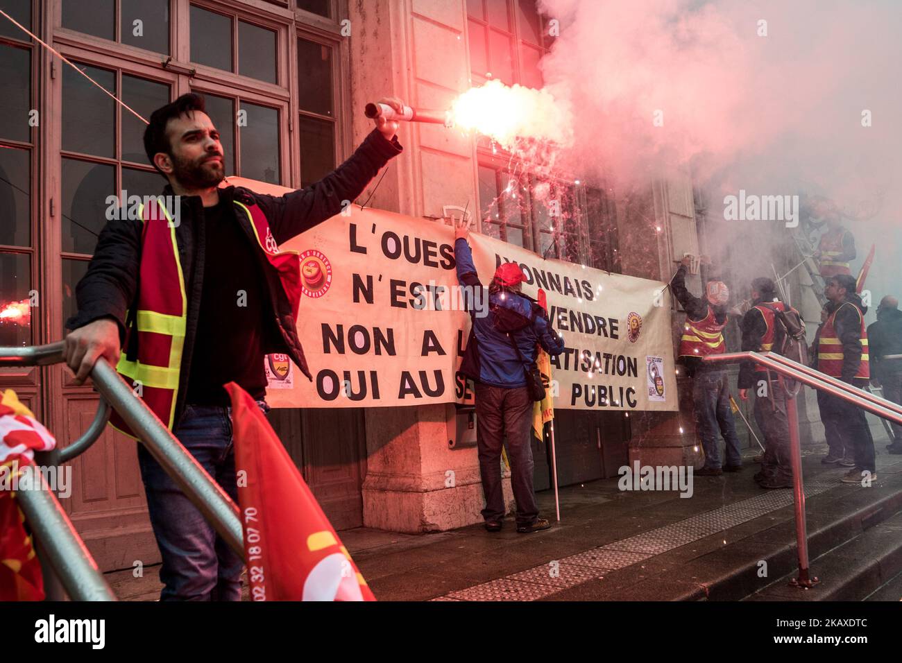 Des manifestants d'employés de la SNCF ont mis une bannière à l'affiche et ont déclenché des éruptions lors d'une manifestation organisée par des cheminots et d'autres syndicats à Lyon, en France, sur 4 avril 2018. Les trains et les avions ont été annulés à travers la France, alors que les syndicats ont poussé vers l'avant, avec des protestations contre le président Emmanuel Macrons, qui prévoyait de retirer les avantages de certains travailleurs de l'État. (Photo de Nicolas Liponne/NurPhoto) Banque D'Images
