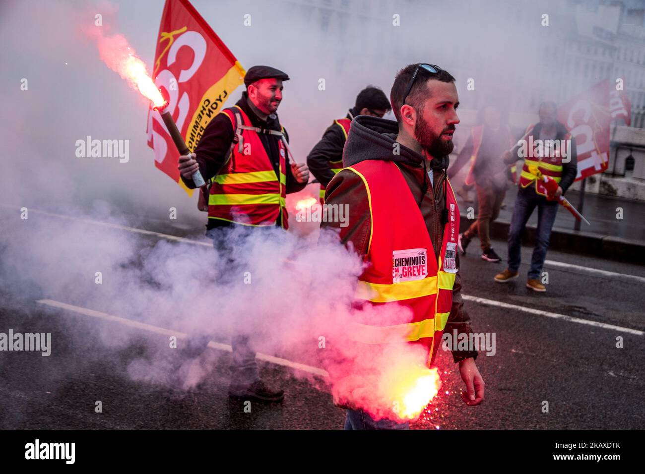 Des manifestants d'employés de la SNCF ont mis une bannière à l'affiche et ont déclenché des éruptions lors d'une manifestation organisée par des cheminots et d'autres syndicats à Lyon, en France, sur 4 avril 2018. Les trains et les avions ont été annulés à travers la France, alors que les syndicats ont poussé vers l'avant, avec des protestations contre le président Emmanuel Macrons, qui prévoyait de retirer les avantages de certains travailleurs de l'État. (Photo de Nicolas Liponne/NurPhoto) Banque D'Images