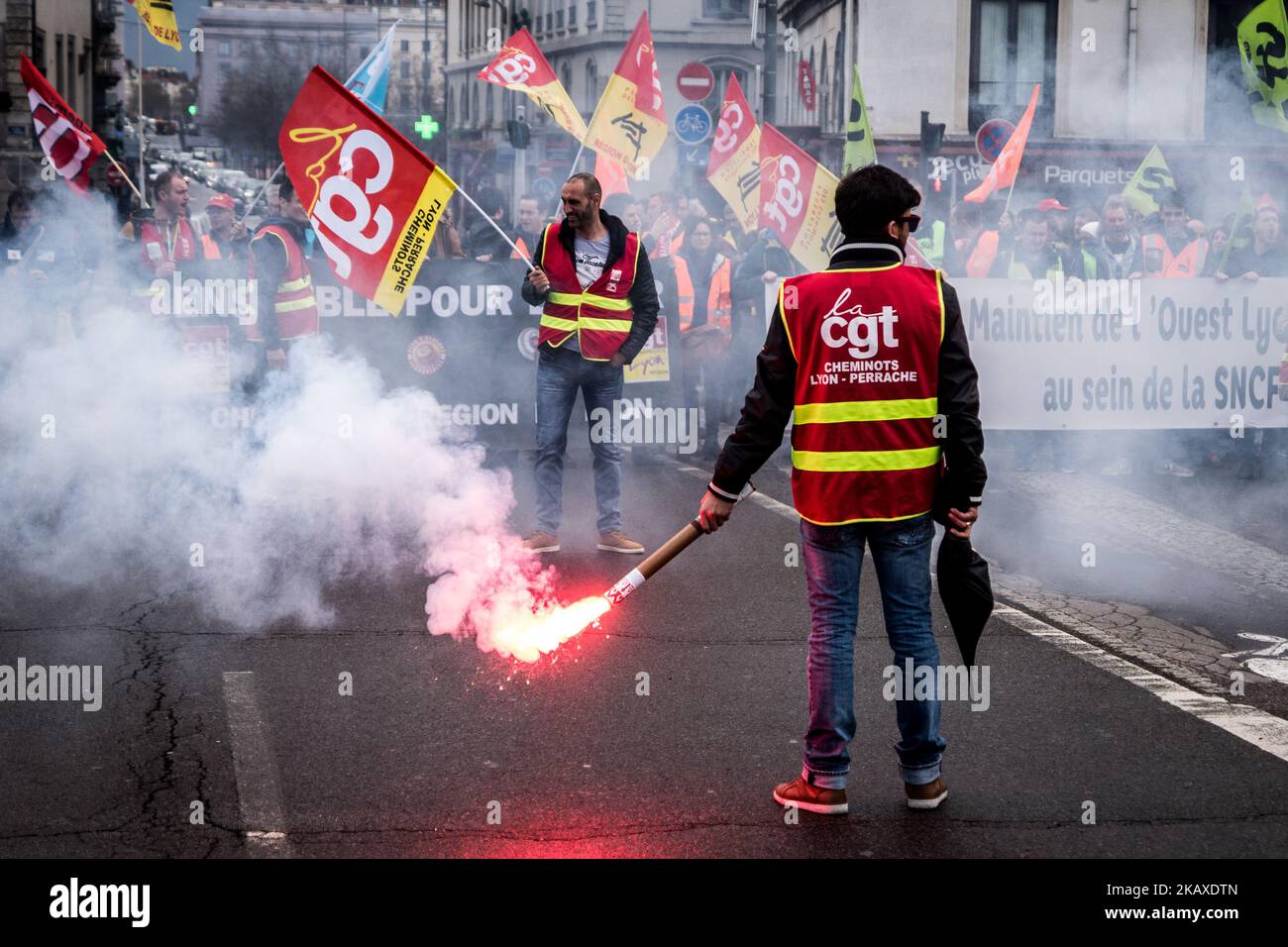 Des manifestants d'employés de la SNCF ont mis une bannière à l'affiche et ont déclenché des éruptions lors d'une manifestation organisée par des cheminots et d'autres syndicats à Lyon, en France, sur 4 avril 2018. Les trains et les avions ont été annulés à travers la France, alors que les syndicats ont poussé vers l'avant, avec des protestations contre le président Emmanuel Macrons, qui prévoyait de retirer les avantages de certains travailleurs de l'État. (Photo de Nicolas Liponne/NurPhoto) Banque D'Images