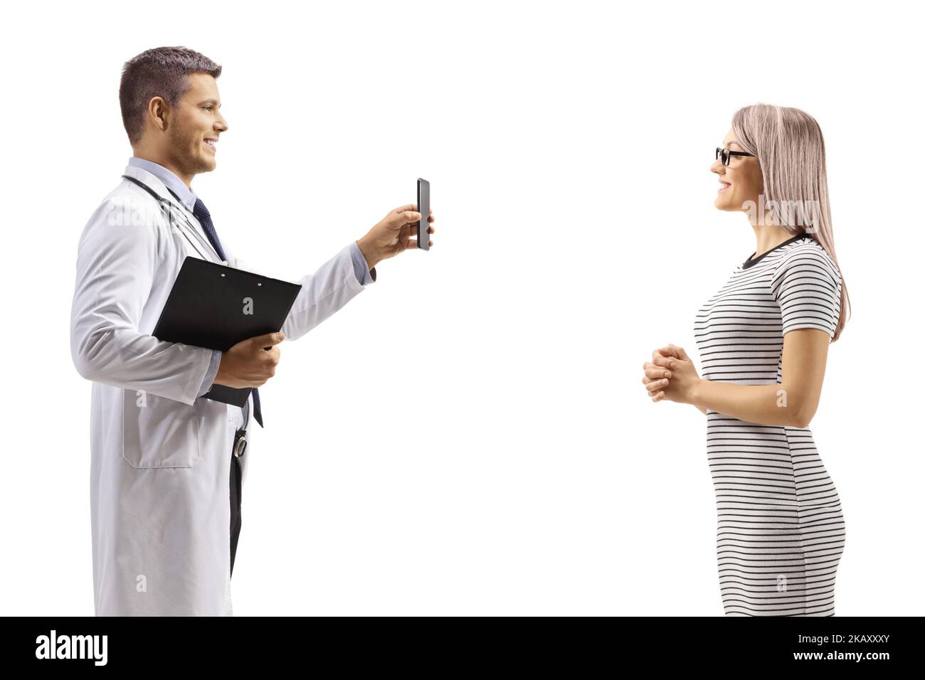 Médecin montrant un téléphone portable à une jeune patiente isolée sur fond blanc Banque D'Images