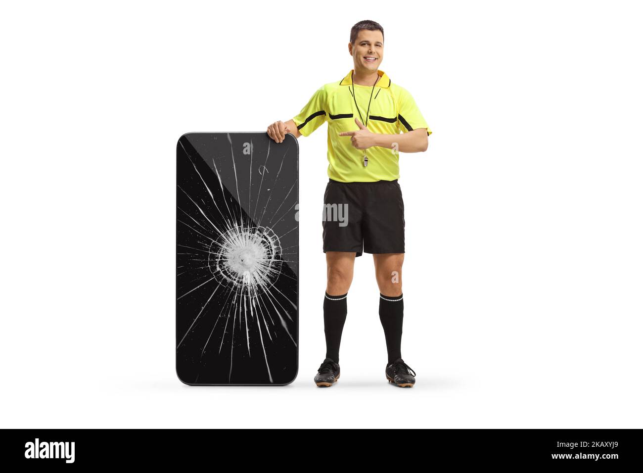 Portrait complet d'un arbitre de football pointant vers un smartphone écran cassé isolé sur fond blanc Banque D'Images