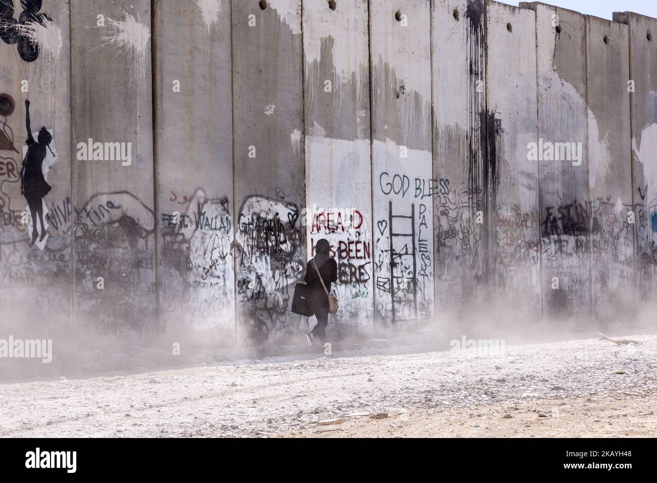 Une femme palestinienne marche à côté d'un mur de sécurité concret construit par Israël pour séparer les Palestiniens d'Israël à Qalandia, Palestine sur 9 juin 2018. Les Palestiniens disent que le mur est illégal et les sépare des autres territoires occupés de Jérusalem-est. (Photo par Dominika Zarzycka/NurPhoto) Banque D'Images