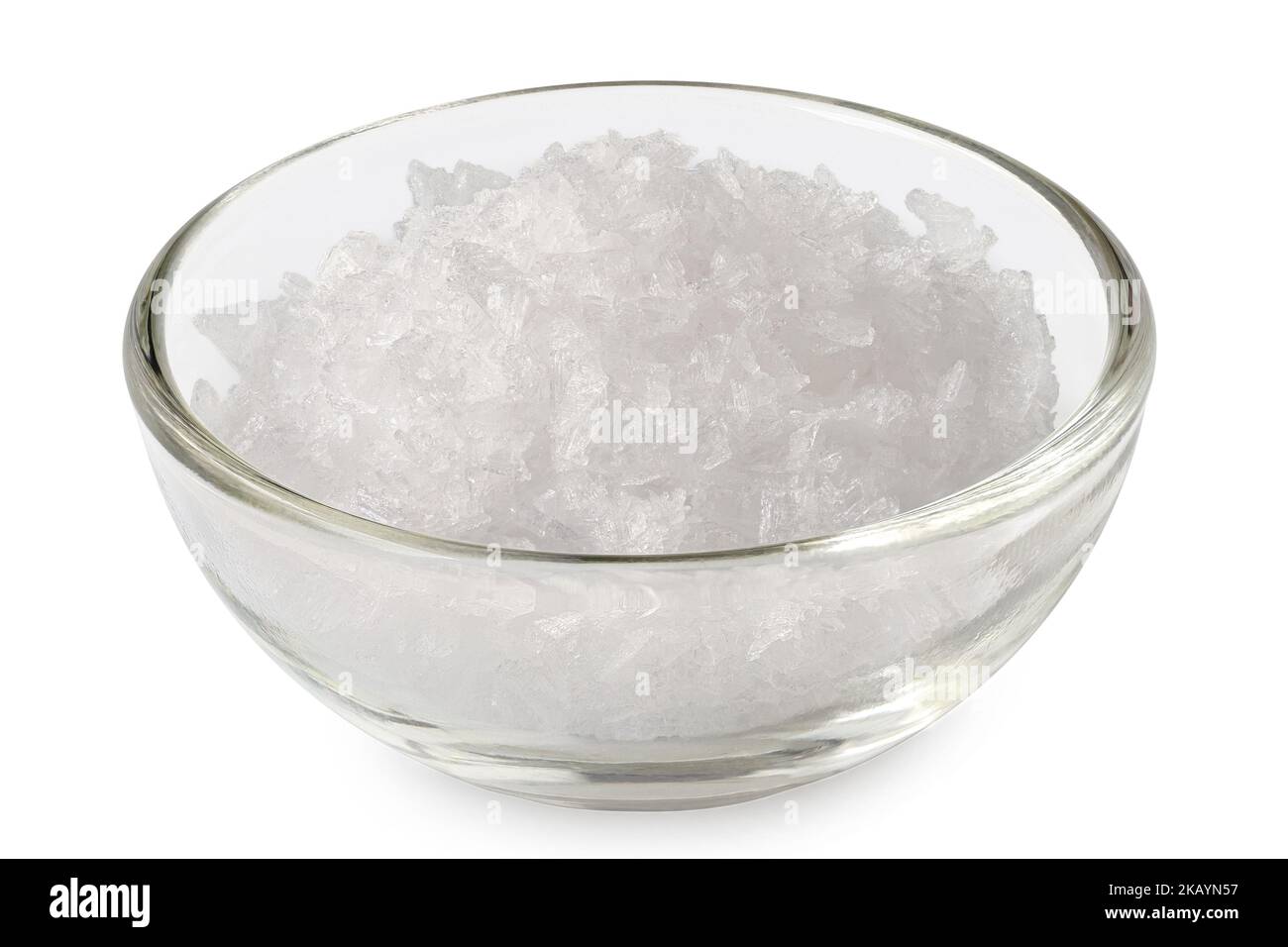 Flocons de sel de mer dans un bol en verre isolé sur blanc. Banque D'Images