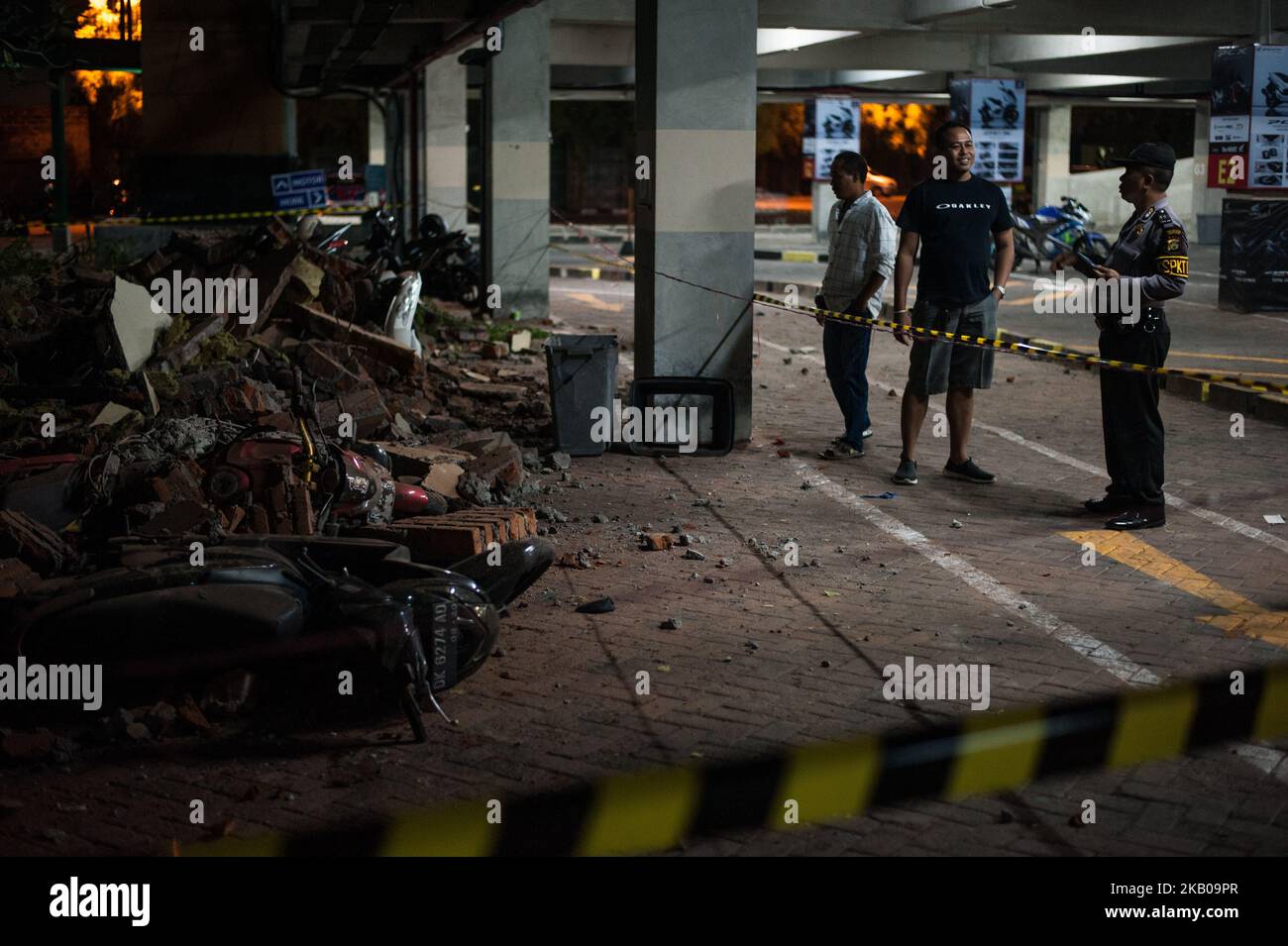 Les agents de sécurité ont surveillé les ruines du bâtiment qui a frappé le parking pour motos du centre commercial Bali Galeria en raison du tremblement de terre sur 5 août 2018 à Badung Regency, Bali, Indonésie. Le tremblement de terre qui s'est produit deux fois avec la force de 6,8 et & 7,0 a été centré sur l'île de Lombok avec le potentiel de tsunami. (Photo de Muhammad Fauzy/NurPhoto) Banque D'Images