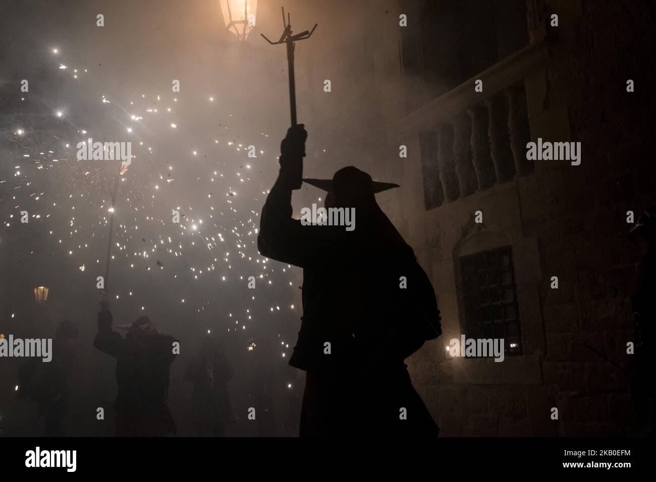 Un diable se rend au milieu des pyrotechniques lors de la célébration du Festival Sant Roc à Barcelone (Espagne) le 18 août 2018. Correcentrs, une tradition catalane ancienne où les gens habillés comme des démons font exploser des pétards et des torches, participez chaque mois d'août aux célébrations du festival Sant Roc dans le quartier gothique de Barcelone. (Photo de Jordi Boixareu/NurPhoto) Banque D'Images