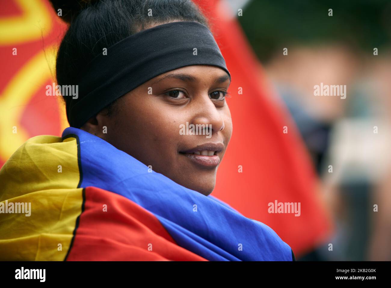 Une jeune femme kanak pose pour une photo tout en se enveloppant dans
