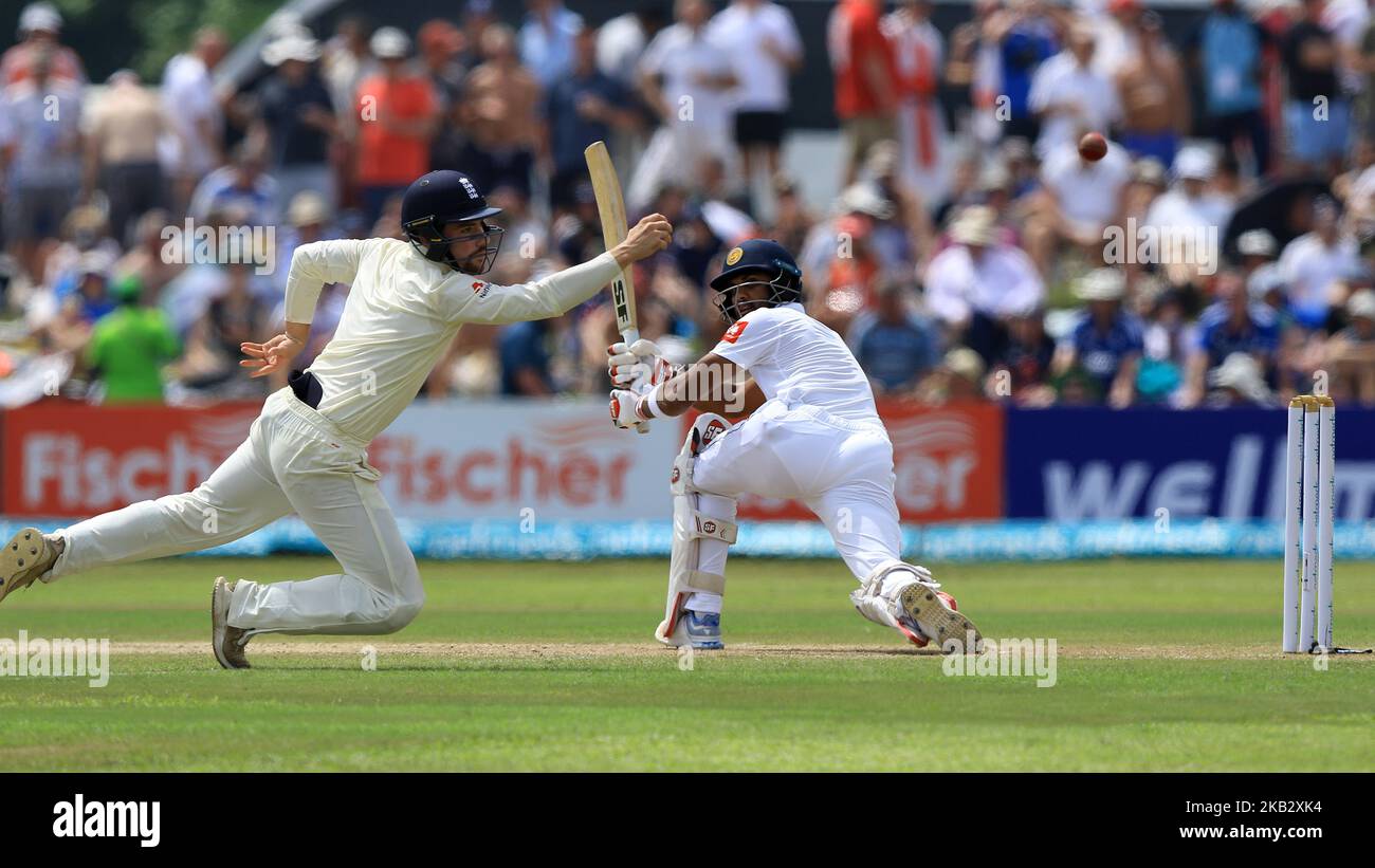 Le joueur de cricket d'Angleterre Rory Burns (L) plonge pour attraper le ballon tandis que le capitaine de cricket du Sri Lanka Dinesh Chandimal regarde pendant le jeu de 2nd jours du premier match de cricket d'essai entre le Sri Lanka et l'Angleterre au stade international de cricket de Galle, Galle, Sri Lanka, le 7 novembre 2018. (Photo de Thharaka Basnayaka/NurPhoto) Banque D'Images