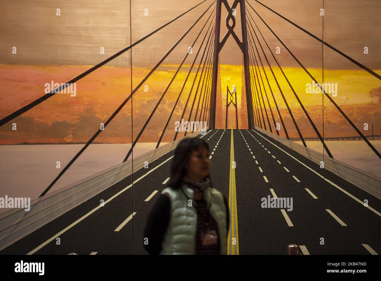 Une femme est vue debout devant un tableau du pont Hong Kong-Zhuhai-Macao dans les remorqueurs de Hong Kong à mes fiefs: Exposition d'art pour marquer 40 ans de réforme et d'ouverture politique» à Hong Kong, Chine, 21 décembre 2018. (Photo de Harry Wai/NurPhoto) Banque D'Images