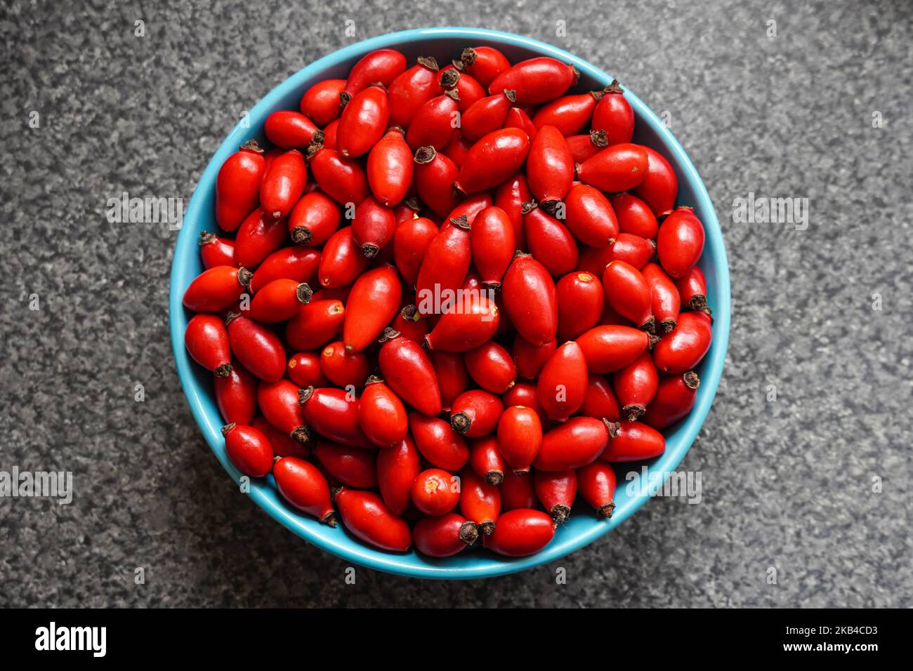 Fruits de bassin fraîchement fourrés de rose rouge fraîche dans un bol Banque D'Images