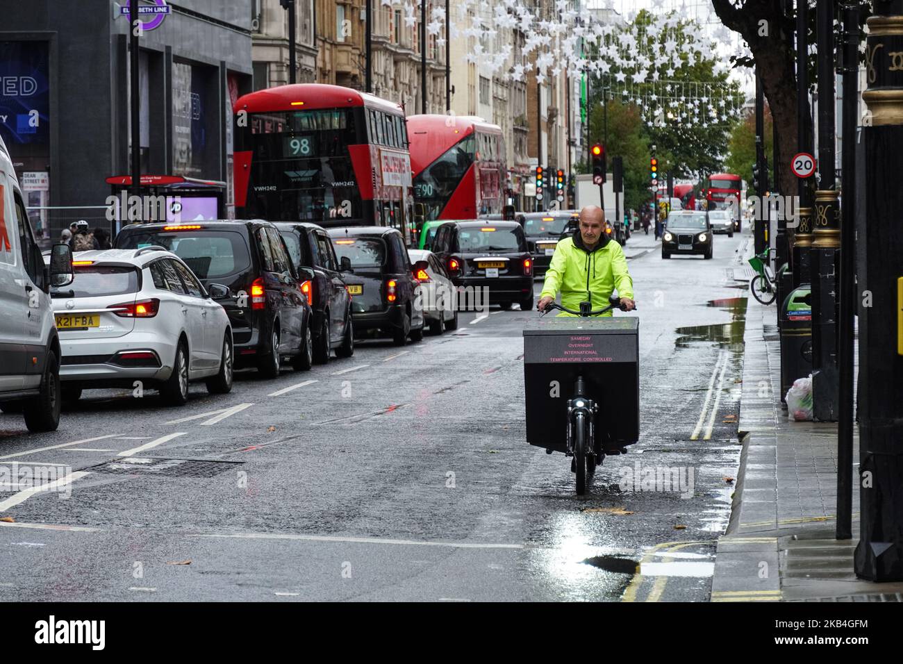 Coursier sur un vélo de cargaison à Londres, Angleterre Royaume-Uni Banque D'Images