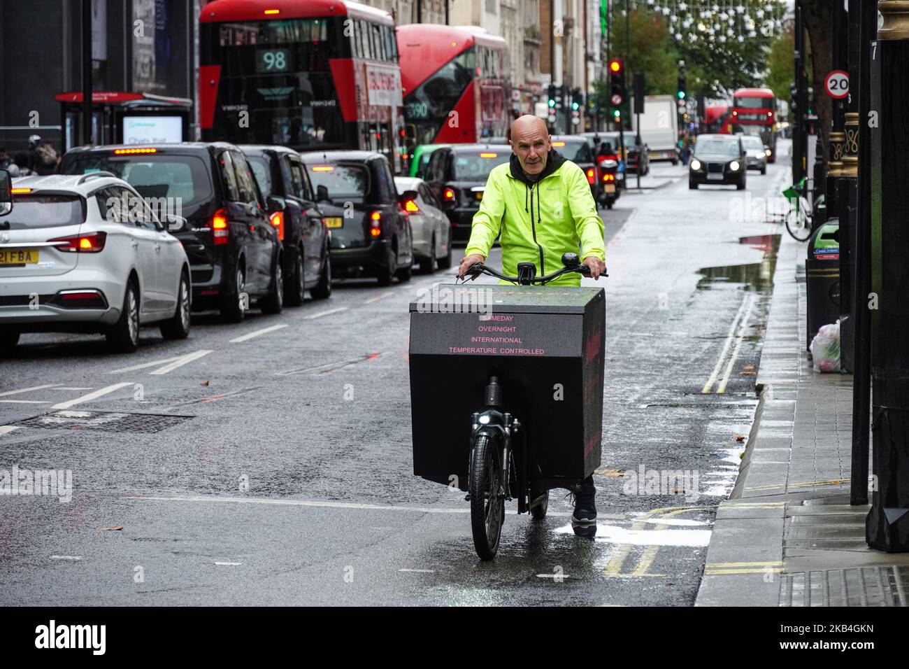 Coursier sur un vélo de cargaison à Londres, Angleterre Royaume-Uni Banque D'Images