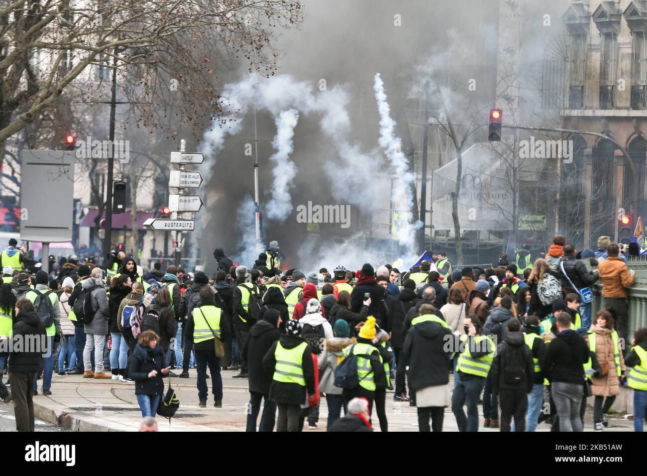 Les manifestants se tiennent en larmes de fumée au gaz lors d'affrontements avec la police lors d'une manifestation antigouvernementale organisée par le mouvement des gilets jaunes (gilets jaunes) sur la place de la Bastille à Paris sur 26 janvier 2019. Les manifestants anti-gouvernement « Yellow Vest » sont descendus dans les rues de France pour le samedi 11th consécutif sur 26 janvier, malgré les récentes divisions dans leurs rangs, Et avec une ténacité affichée face à un exécutif qui retrouve sa popularité dix jours après l'ouverture du « grand débat national », la tentative du président français de prouver qu'il va prendre en compte la critique féroce de « Banque D'Images