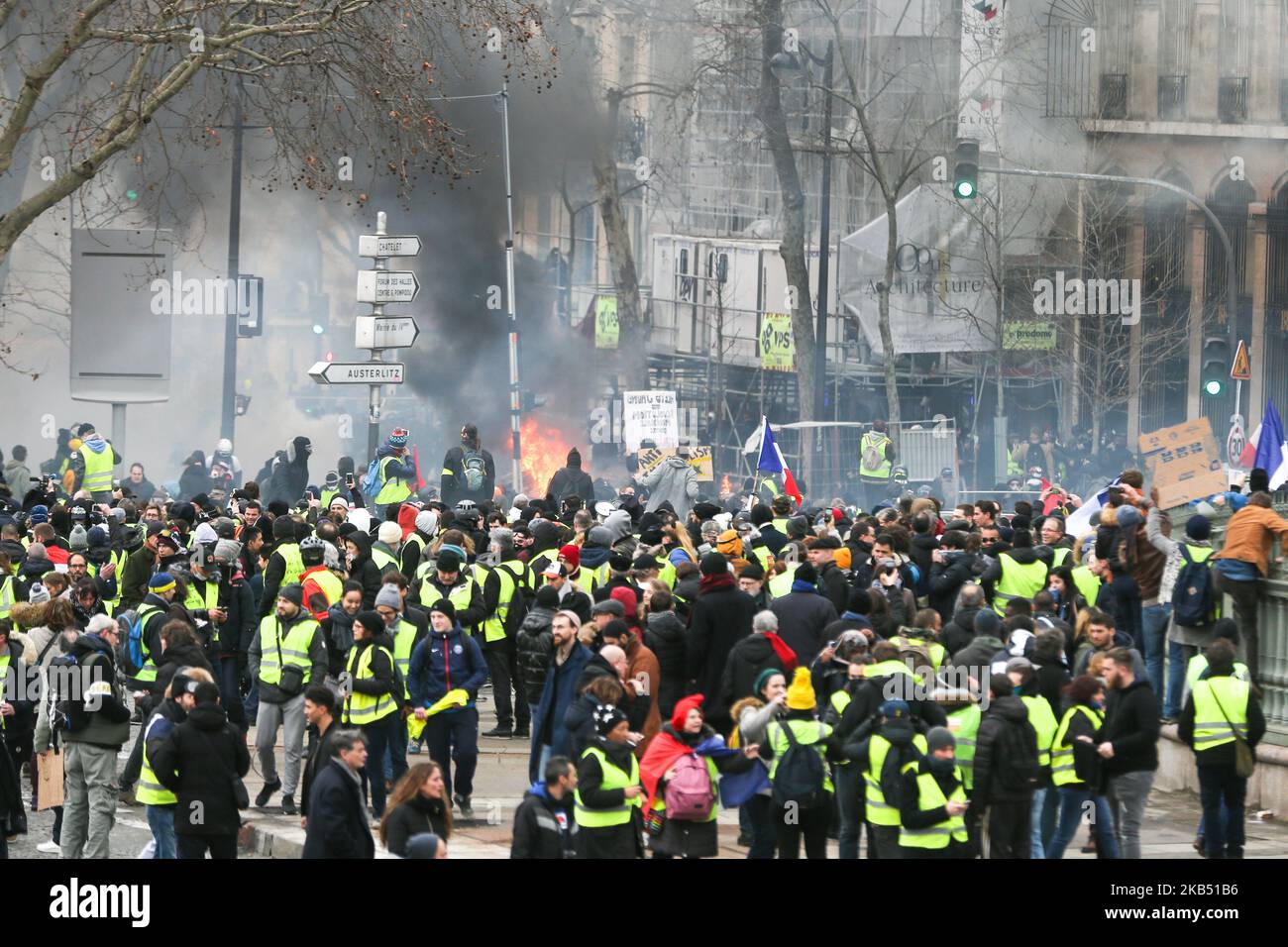 Les manifestants se tiennent derrière une barricade brûlante lors d'une manifestation anti-gouvernementale organisée par le mouvement des gilets jaunes (gilets jaunes) près de la place de la Bastille à 26 janvier 2019. Les manifestants anti-gouvernement « Yellow Vest » sont descendus dans les rues de France pour le samedi 11th consécutif sur 26 janvier, malgré les récentes divisions dans leurs rangs, Et avec une ténacité affichée face à un exécutif qui regagné en popularité dix jours après l'ouverture du « grand débat national », la tentative du président français de prouver qu'il prendra à son compte la critique féroce de la « veste jaune » Banque D'Images