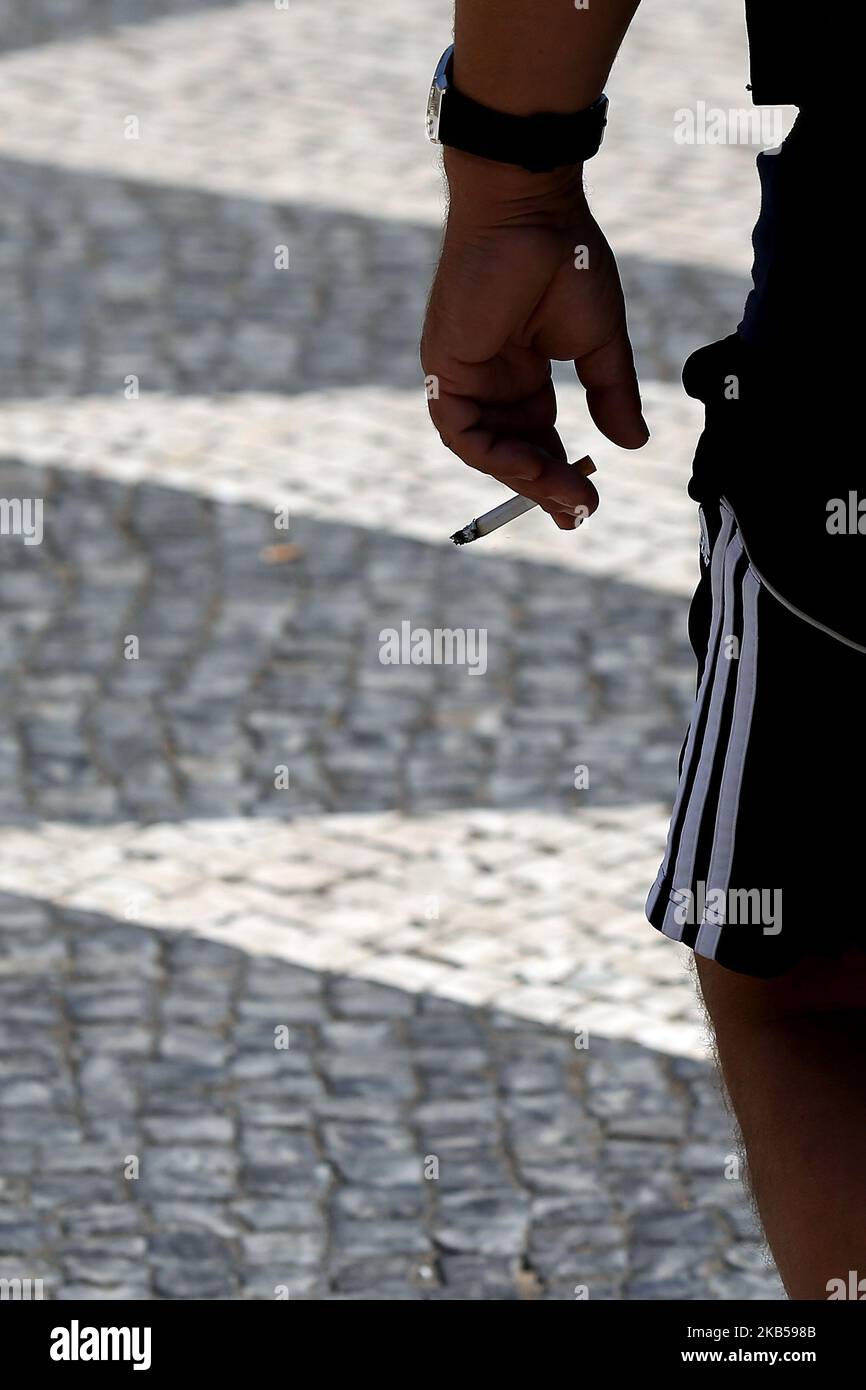 Un fumeur tient une cigarette à Lisbonne, au Portugal, sur 4 septembre 2019. La loi approuvant les mesures pour la collecte et le traitement des déchets de tabac et punit avec des amendes entre 25 et 250 euros ceux qui jettent des boires sur la voie publique a été publiée sur le Journal de 3 septembre en République. Les mégots de cigarettes, les cigares ou autres cigarettes contenant des produits du tabac seront assimilés, à partir d'aujourd'hui, aux déchets urbains solides, et leur élimination dans l'espace public est donc interdite. (Photo par Pedro Fiúza/NurPhoto) Banque D'Images