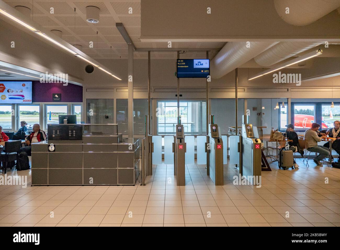 Portes d'embarquement et auto-contrôle des billets avec des panneaux et un  écran dans le hall des départs, à l'intérieur du terminal de l'aéroport  international d'Alesund AES ENAL, Vigra, desservant la ville d'Alesund