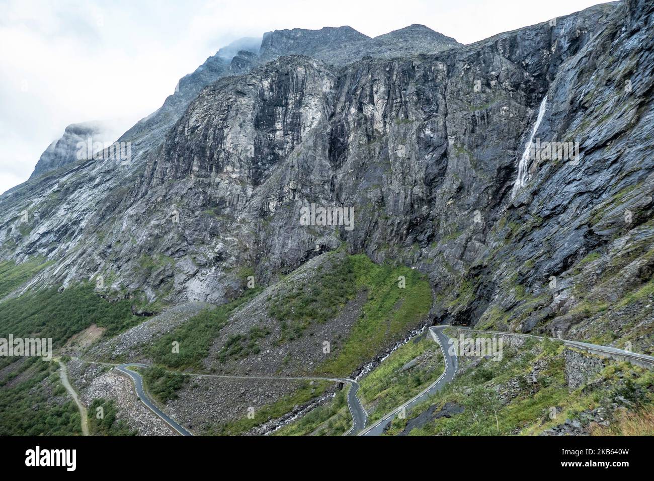 Célèbre Serpentine Scenic Mountain Road Trollstigen ou Trollstigveien, le Trollpath, une route de montagne avec des cascades dans la municipalité de Rauma, More og Romsdal comté, Norvège. La route fait partie de la route 63 du comté de Norvège, reliant Andalsnes au fjord de Valldal et Geiranger, Trollstigen fait partie de la route panoramique norvégienne Geiranger - Trollstigen. La route n'est ouverte que pendant la saison estivale, elle est étroite avec des virages serrés, montant de 850 mètres, avec une grande cascade, Stigfossen d'une hauteur de 240 mètres et un pont, centre de visiteurs pour les touristes, plate-forme d'observation des visiteurs. La vue du Scandi Banque D'Images