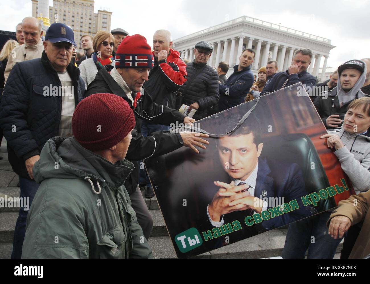 Les manifestants attaquent un partisan du président ukrainien Volodymyr Zelensky (L) qui tient une pancarte sur sa photo et qui lit « You are our Fresh Blood! », lors d'une protestation contre la mise en œuvre de la « Formule thé », sur la place de l'indépendance à Kiev, en Ukraine, le 06 octobre 2019. Le 1 octobre, 2019 membres du Groupe de contact trilatéral sur l'Ukraine ont convenu d'un processus de paix connu sous le nom de 'Formule de la téinmeier', comme l'ont indiqué les médias locaux. (Photo par STR/NurPhoto) Banque D'Images