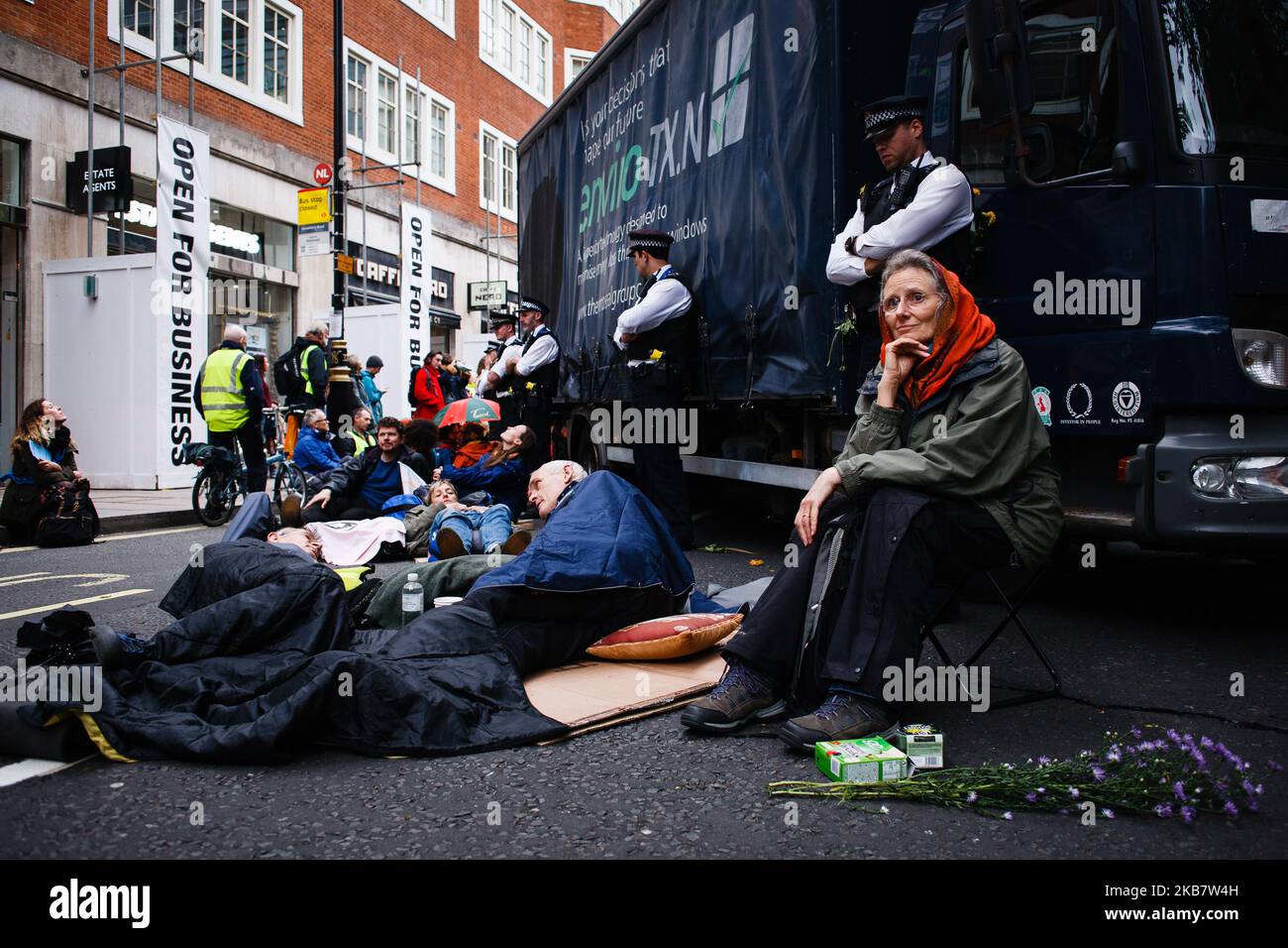 Les membres du groupe d'activistes sur le changement climatique extinction Rebellion (XR) s'assoient à côté d'un camion bloquant Marsham Street devant le siège social le jour d'ouverture de la « rébellion internationale » du groupe, planifiée de longue date à Londres, en Angleterre, sur 7 octobre 2019. Les membres du groupe ont l'intention d'occuper 12 sites autour de bâtiments gouvernementaux à Westminster jusqu'au samedi prochain, au moins, à 19 octobre, dans le but de « faire descendre » la zone pour faire pression sur les législateurs afin de prendre des mesures plus rapides et plus rapides pour stopper la perte de biodiversité et réduire les émissions de gaz à effet de serre. Des blocus similaires par extinction rébellion dans la ville en avril, sur des sites Banque D'Images