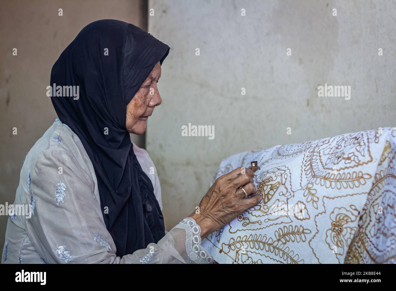 Une femme artiste batik créant divers dessins avec un outil de type stylo appelé une canting dans le cadre du processus de fabrication de batik indonésien à Bantul, Yogyakarta, Indonésie sur 15 octobre 2019. Le batik est l'art et la culture d'origine de l'Indonésie faite avec un tissu qui utilise traditionnellement une technique générique de teinture résistant à la cire. (Photo de Rizqullah Hamiid/NurPhoto) Banque D'Images