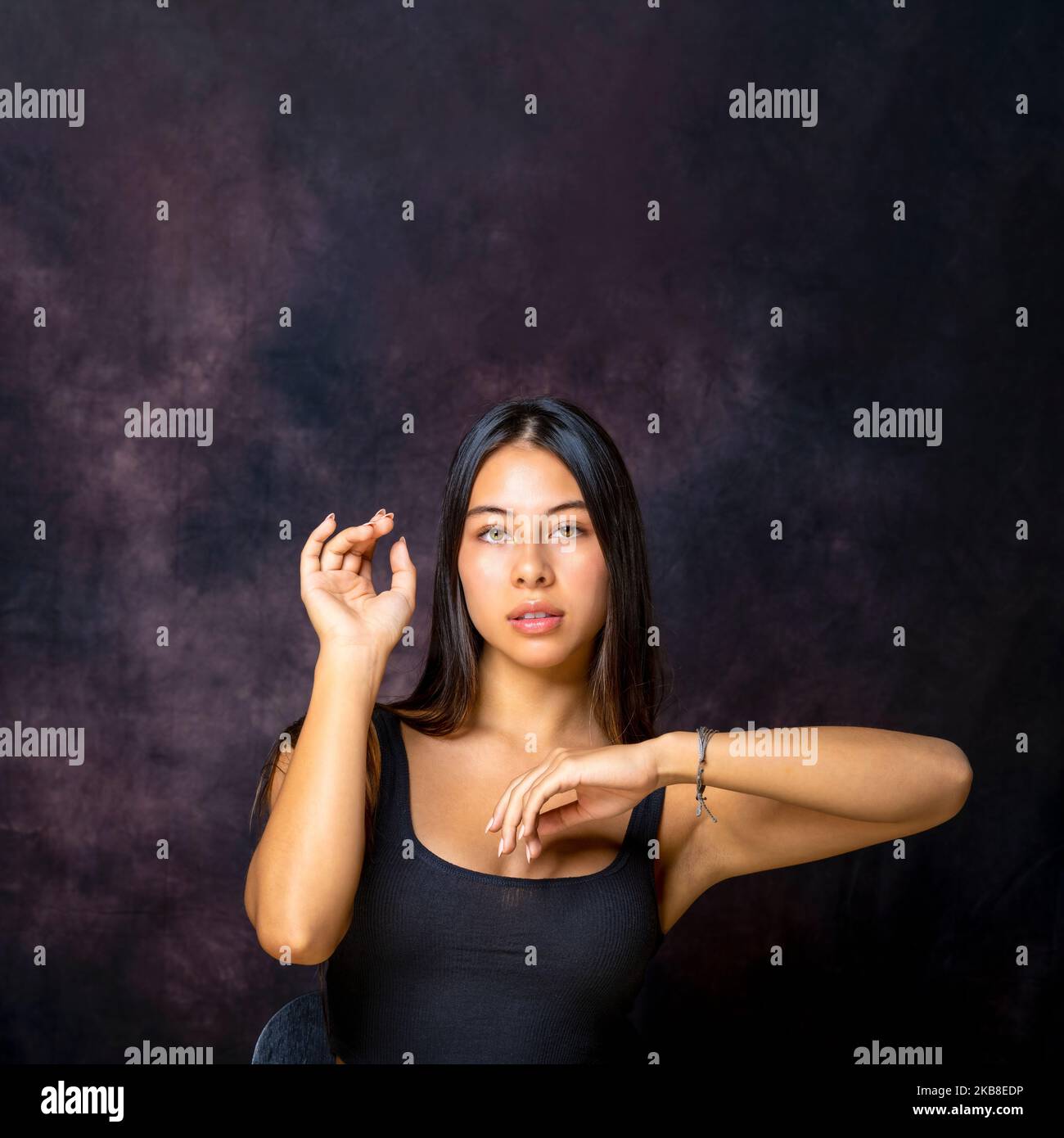 Teen multiracial assis bras dans la posture de danse avec l'espace de copie au-dessus d'elle Banque D'Images