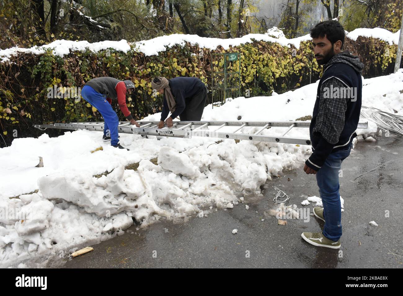 Employés du département de développement de l'énergie PDD travaille sur des lignes endommagées après que la vallée a été témoin de fortes chutes de neige dans la banlieue de Srinagar, au cachemire administré par l'Inde le 08 novembre 2019. La vallée du Cachemire a reçu jeudi sa première chute de neige qui a endommagé des biens à de nombreux endroits a entraîné la mort de sept personnes. (Photo de Muzamil Mattoo/NurPhoto) Banque D'Images