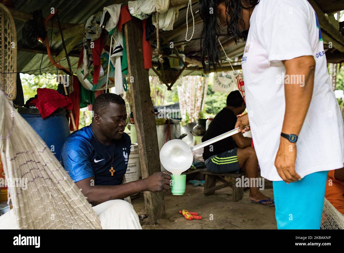 Maripasoula, France, 28 juin 2019. Le père Herve Cleze Moutaleno boit Cachiri, une boisson traditionnelle amérindienne avec ses fidèles dans le village d'Antekum Pata. Ce missionnaire congolais est attaché à la paroisse d'Antekum Pata parmi le peuple Wayana, l'un des six peuples amérindiens indigènes vivant en Guyane française. (Photo par Emeric Fohlen/NurPhoto) Banque D'Images