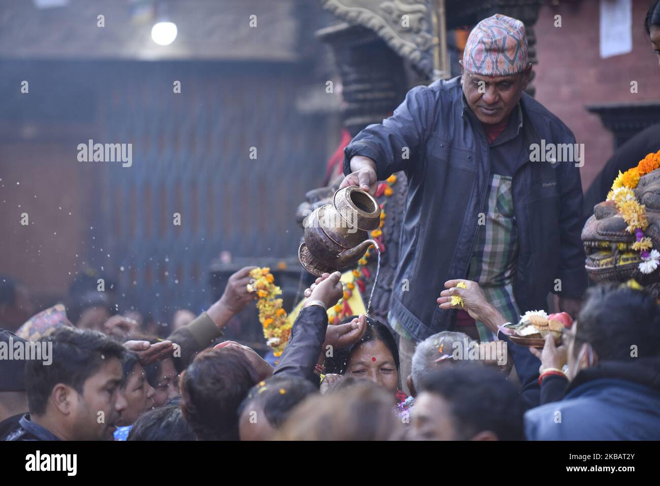 Un prêtre offrant de l'eau sainte aux dévotés le dernier jour du festival Adinath Mela à Chobhar, Kirtipur, Katmandou, Népal, mardi, 12 novembre, 2019. Au mois d'octobre ou novembre de Kojagrat purnima à Kartik purnima pendant un mois, les gens visitent le temple d'Adinath le matin pour effectuer des rituels spéciaux puja et fonction rituelle pendant Adinath Mela. (Photo de Narayan Maharajan/NurPhoto) Banque D'Images