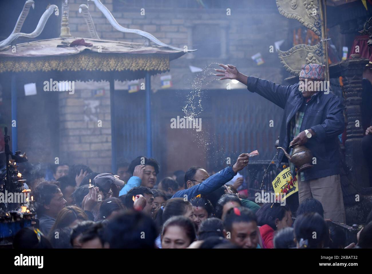 Un prêtre offrant de l'eau sainte aux dévotés le dernier jour du festival Adinath Mela à Chobhar, Kirtipur, Katmandou, Népal, mardi, 12 novembre, 2019. Au mois d'octobre ou novembre de Kojagrat purnima à Kartik purnima pendant un mois, les gens visitent le temple d'Adinath le matin pour effectuer des rituels spéciaux puja et fonction rituelle pendant Adinath Mela. (Photo de Narayan Maharajan/NurPhoto) Banque D'Images