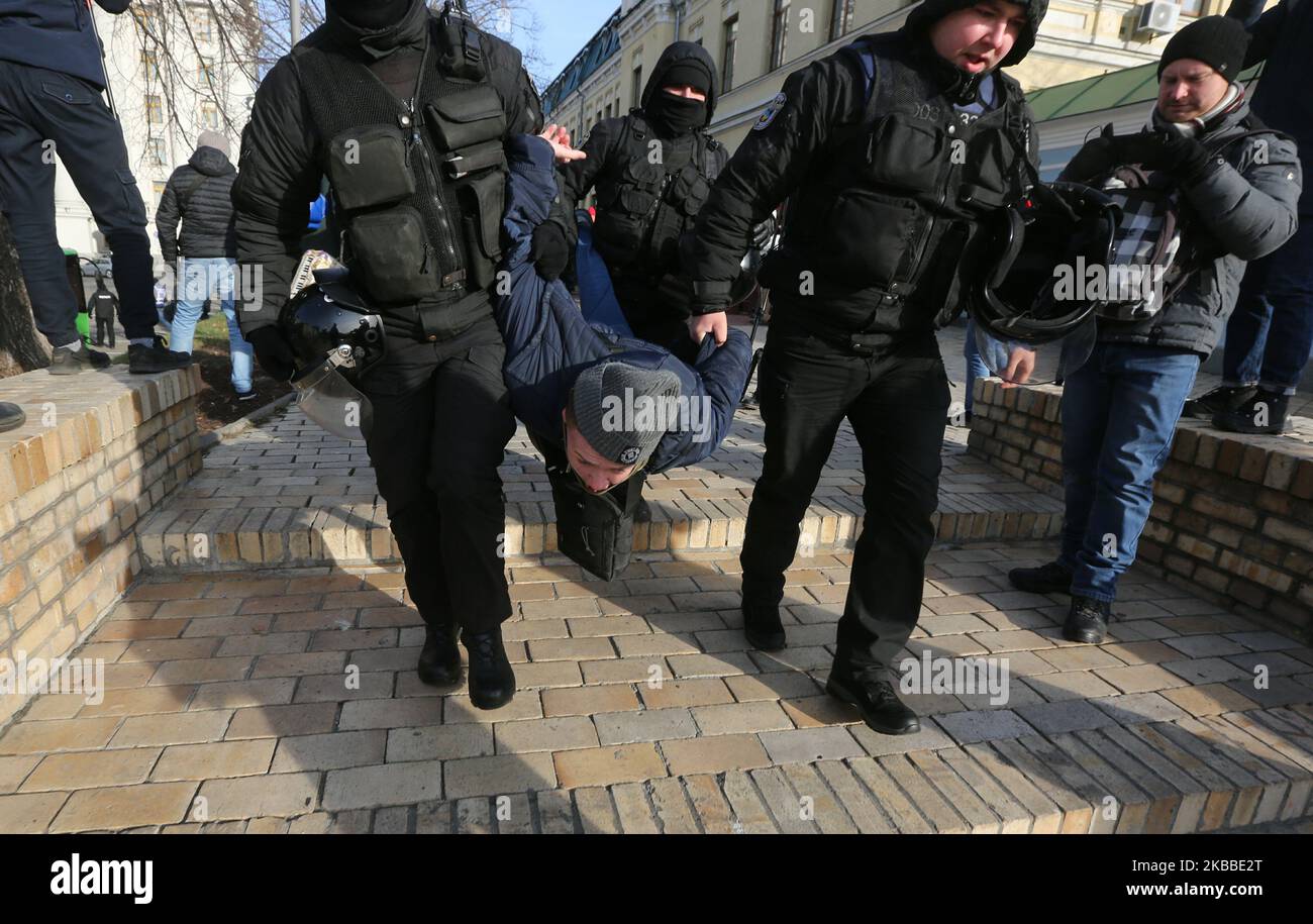 La police porte un militant d'extrême droite détenu qui a protesté contre un rassemblement anti-transphobie à Kiev, en Ukraine, au 23 novembre 2019. Des dizaines de personnes participent au rassemblement pour marquer la Journée internationale de commémoration des personnes transgenres tuées par transphobie en 20th. (Photo par Sergii Kharchenko/NurPhoto) Banque D'Images