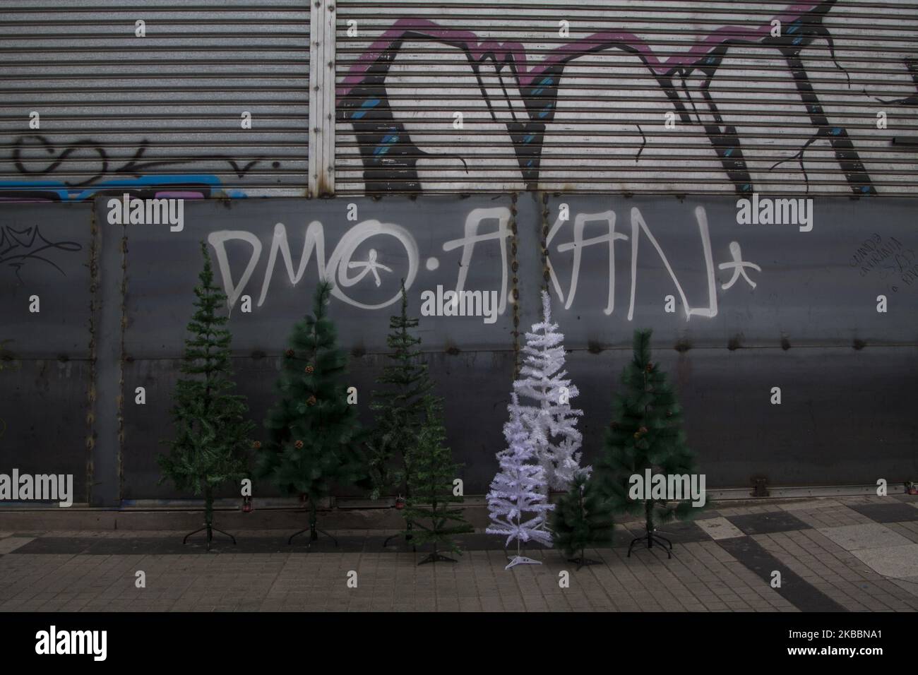 Un magasin commercial expose des arbres de Noël en promotion, devant ses portes blindées. Maipú, Santiago du Chili le 25 novembre 2019. Après le pillage et l'incendie de magasins commerciaux dans la commune de Maipú, les propriétaires ont décidé de protéger entièrement les locaux pour prévenir le vol. Le commerce se poursuit à un rythme lent. (Photo de Claudio Abarca Sandoval/NurPhoto) Banque D'Images