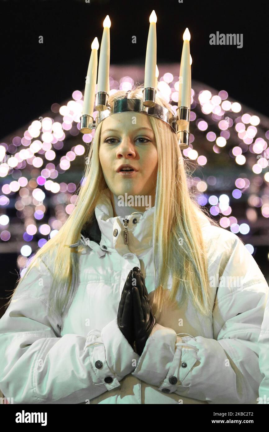 Les jeunes filles de Kalmar, Suède vêtues d'une robe blanche et d'une ceinture rouge (symbole du martyre) portent des bougies en procession le long de la foire de Noël de Gdansk dans la région du centre de la vieille ville sont vues à Gdansk, Pologne, le 2 décembre 2019 . L'un d'eux porte une couronne de bougies sur sa tête. Les filles vêtues de Sainte Lucy (Sankta Lucia) portent des biscuits en procession et chantent des chansons. Il est dit que célébrer avec vivile la Saint Lucy's Day aidera à vivre les longs jours d'hiver avec suffisamment de lumière. (Photo de Michal Fludra/NurPhoto) Banque D'Images