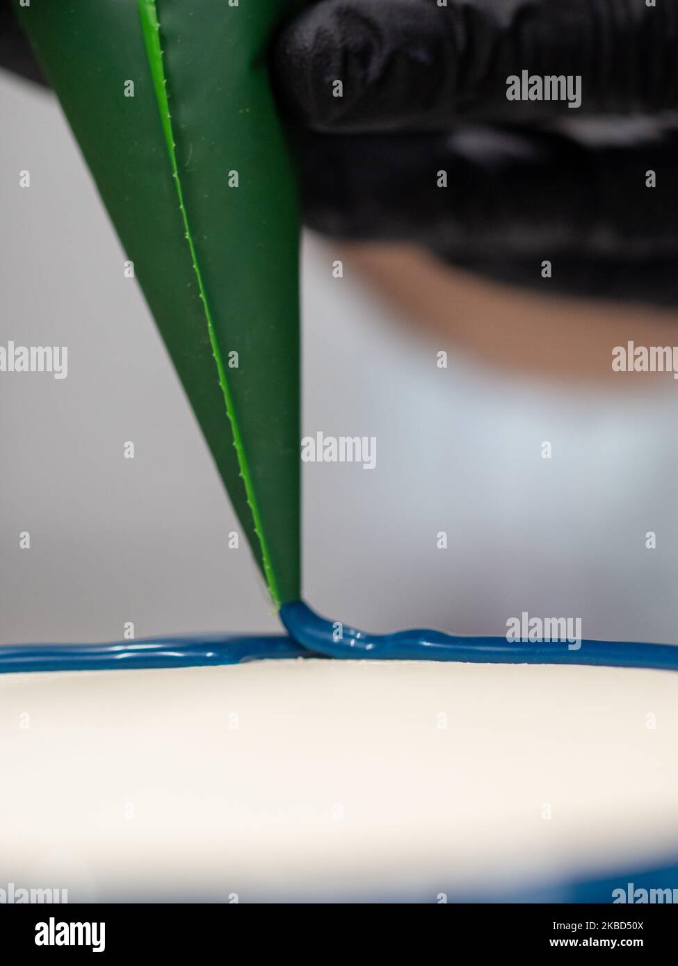 chef pâtissier concepteur de gâteaux préparant un cheesecake blanc bleu dans un laboratoire de cuisine Banque D'Images