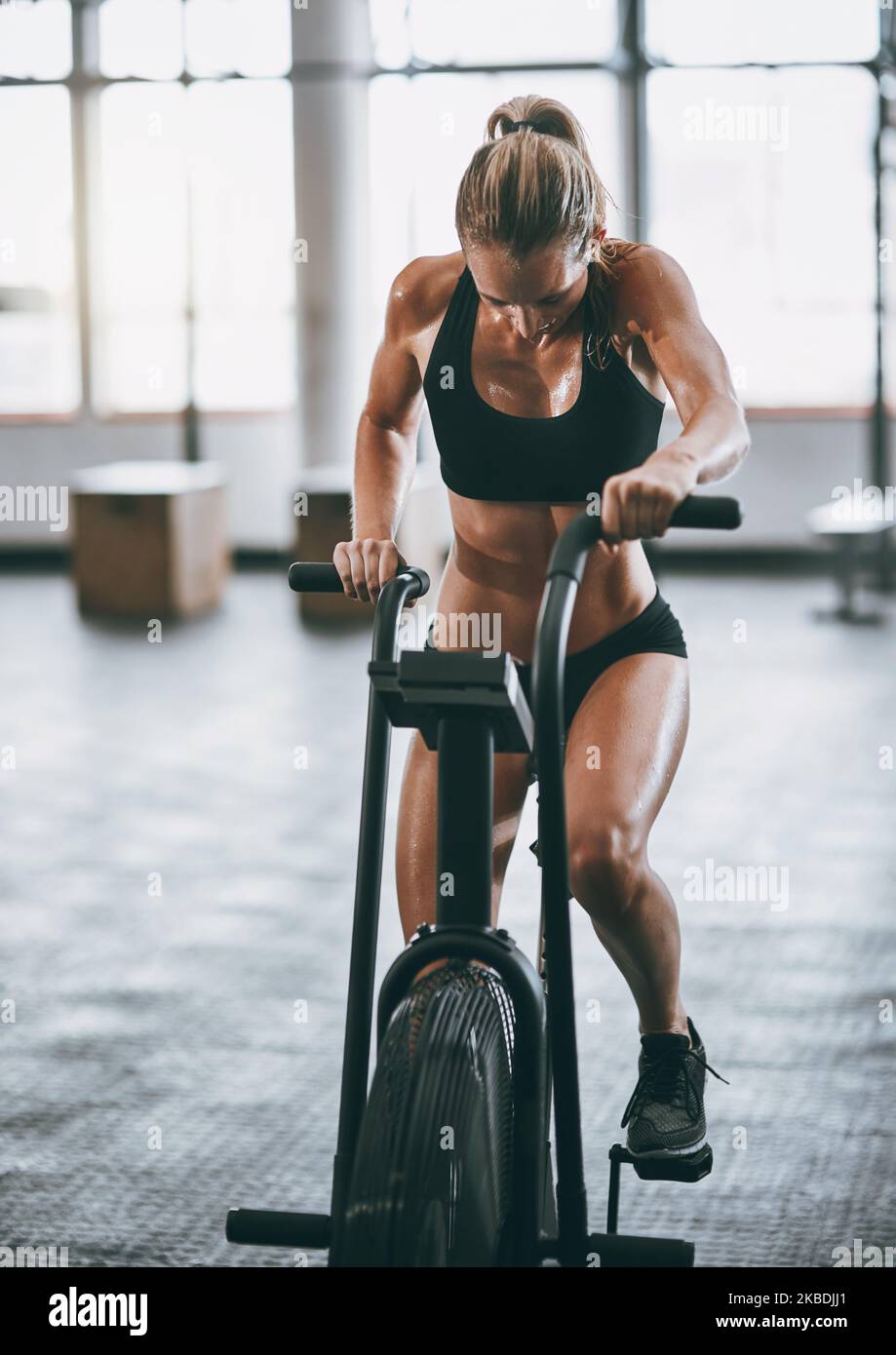 Vos jambes suivront. Une femme qui s'efforce sur une machine elliptique. Banque D'Images