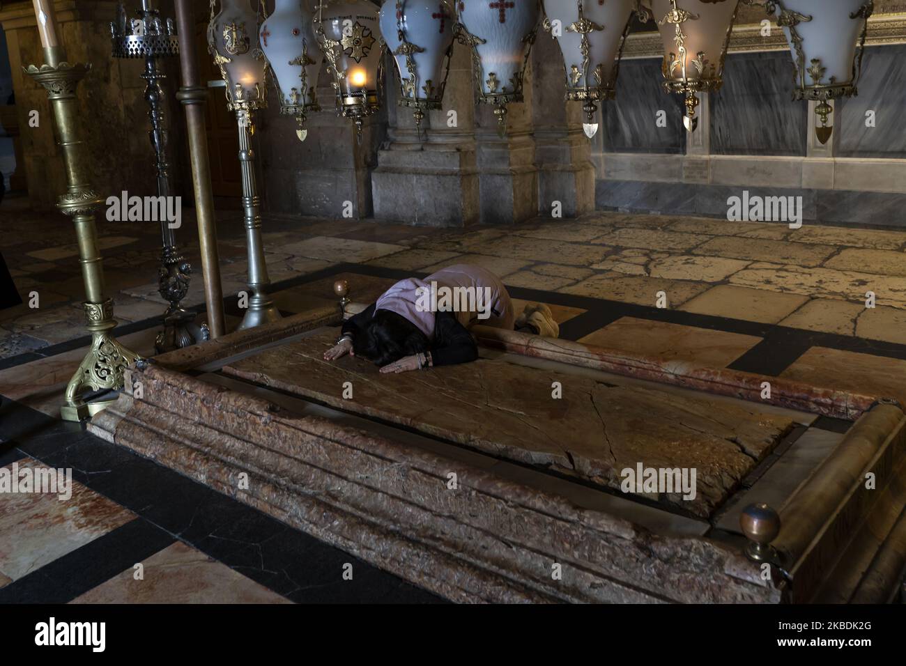 Un pèlerin touche la Pierre de l'onction à Jérusalem, Israël, le 10 décembre 2019. Situé en face de l'entrée de l'église, ce coin du Saint-Sépulcre est considéré comme l'endroit où le corps de Jésus a été oint après avoir été abaissé de la croix. (Photo de Joaquin Gomez Sastre/NurPhoto) Banque D'Images