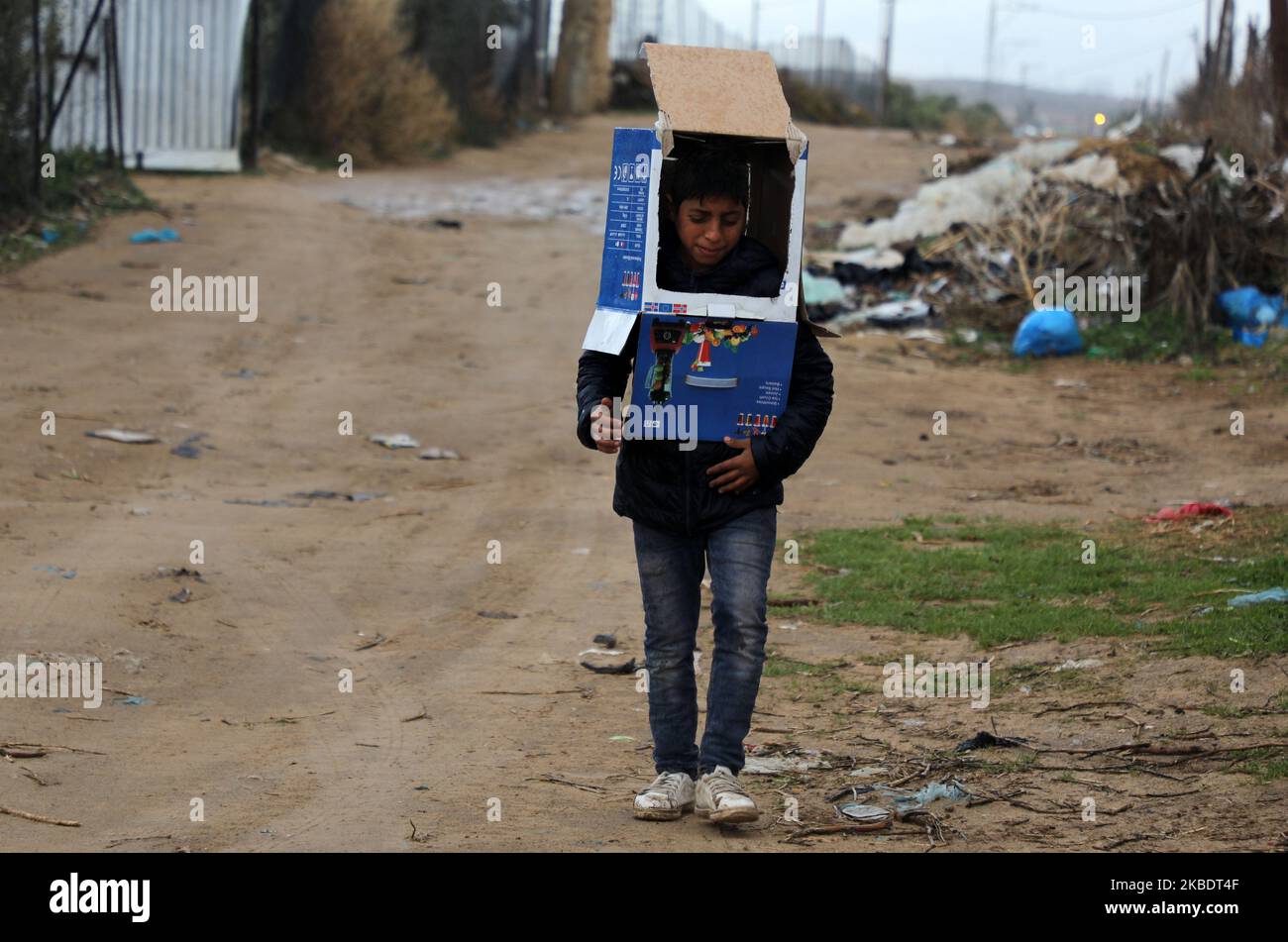 Un garçon bédouin palestinien se protège de la pluie lors de fortes pluies dans la ville de Gaza sur 4 janvier 2020. (Photo de Majdi Fathi/NurPhoto) Banque D'Images