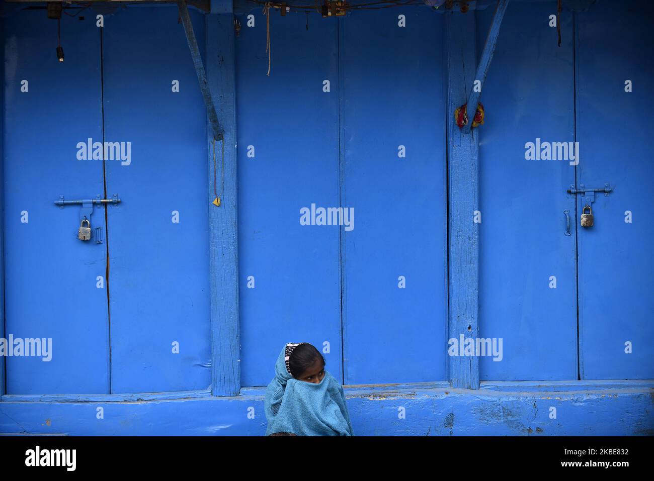 Une petite fille couvre son visage avec le châle que la vente de légumes frais tôt le matin à Bhaktapur, Népal sur 11 janvier 2020. (Photo de Narayan Maharajan/NurPhoto) Banque D'Images