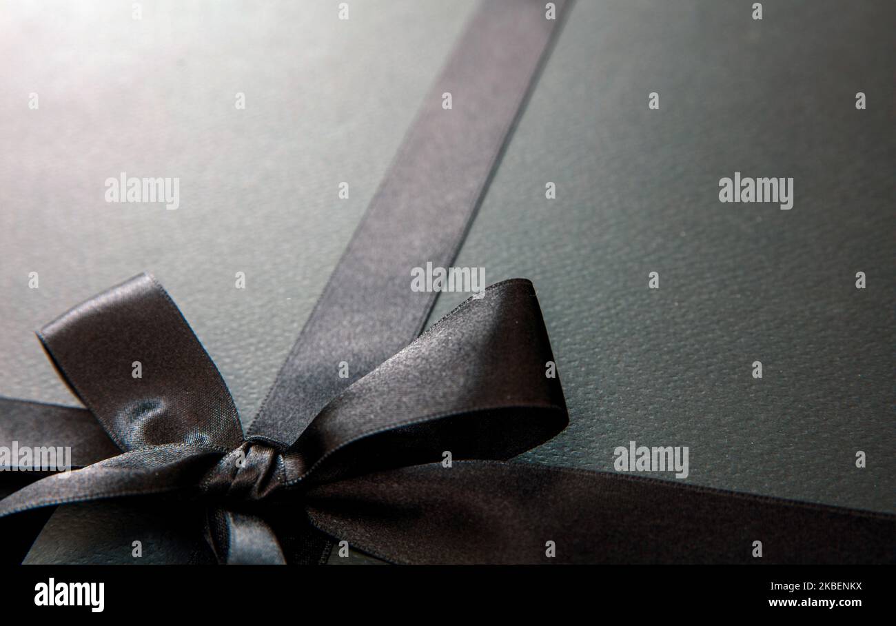 Vente du Vendredi fou et cadeaux de Noël. Ruban en satin noir et noeud, vue rapprochée. Banque D'Images