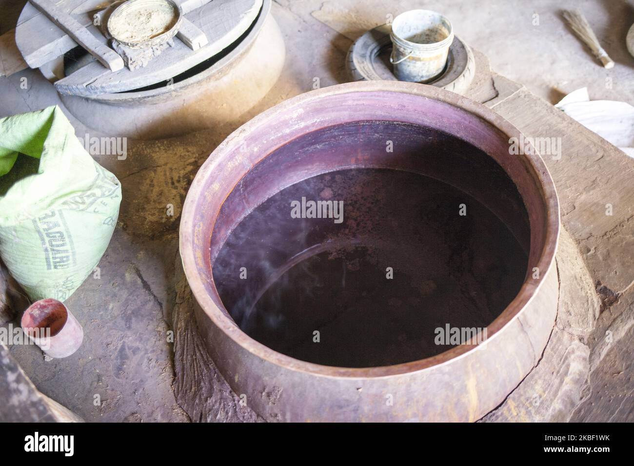 Des teintures naturelles de grenade sont cuites sur le poêle à Bagru, district de Jaipur, Rajasthan, Inde, le 17 mars 2019. Les excréments sont ensuite utilisés pour brûler le poêle pour faire bouillir l'eau avec des colorants naturels. L'impression sur tissus est une spécialité indienne, l'impression en blocs de bois est déjà utilisée depuis des centaines d'années. Bagru est célèbre pour l'impression exclusivement avec des couleurs naturelles. Les principaux experts sont membres de la communauté chippaa. (CHHI - colorant, pa - laisser quelque chose sécher au soleil). Les sections locales estiment qu'il y a environ 200 ateliers d'impression dans et autour de Bagru, qui teintures des tissus à l'aide de pâte de boue, na Banque D'Images