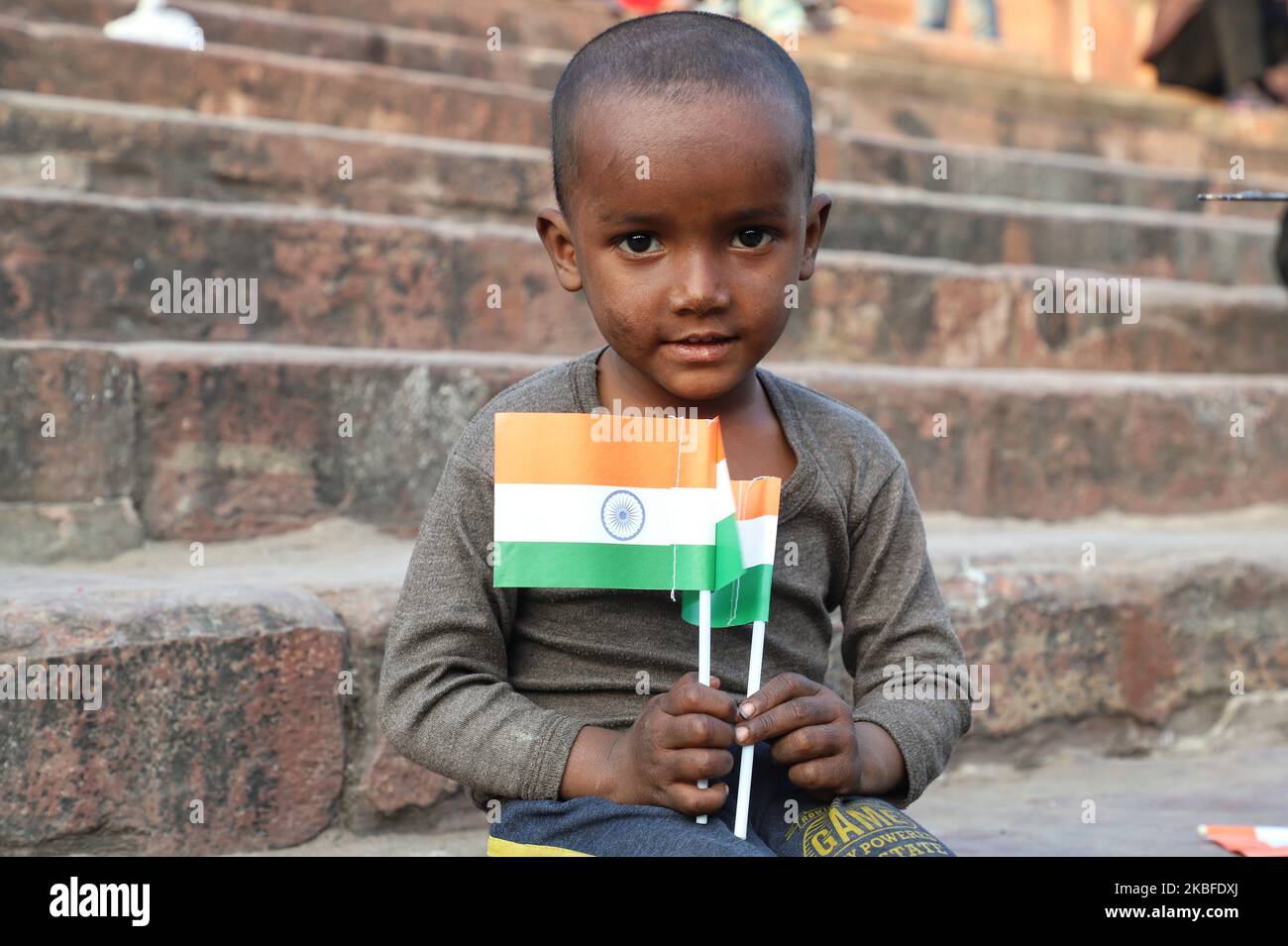 Un garçon sans domicile tient le drapeau national indien (Tri-Color) alors qu'il est assis sur les escaliers de Jama Masjid dans les vieux quartiers de Delhi, Inde, le 26 janvier 2020 (photo de Nasir Kachroo/NurPhoto) Banque D'Images