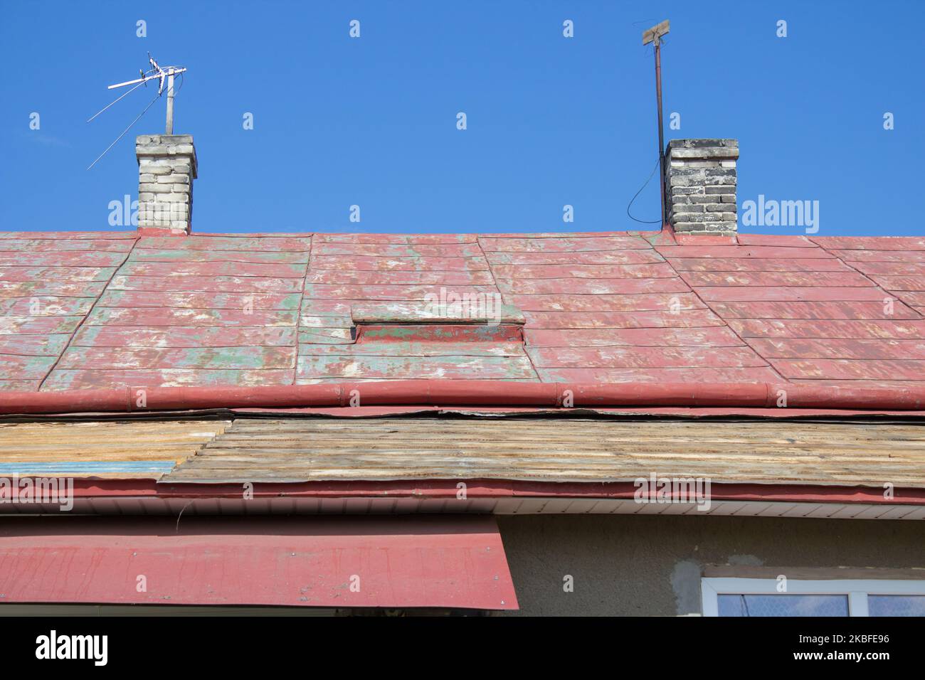 Vieux toit rouge rouille sur la maison Banque D'Images