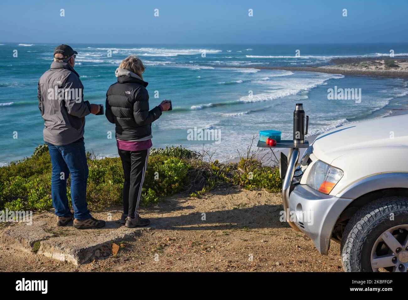 Les touristes apprécient le café lors d'un voyage en voiture, en regardant Struis point et Saxon Reef depuis les falaises près de Waenhuiskrans, Arniston, Afrique du Sud. Banque D'Images