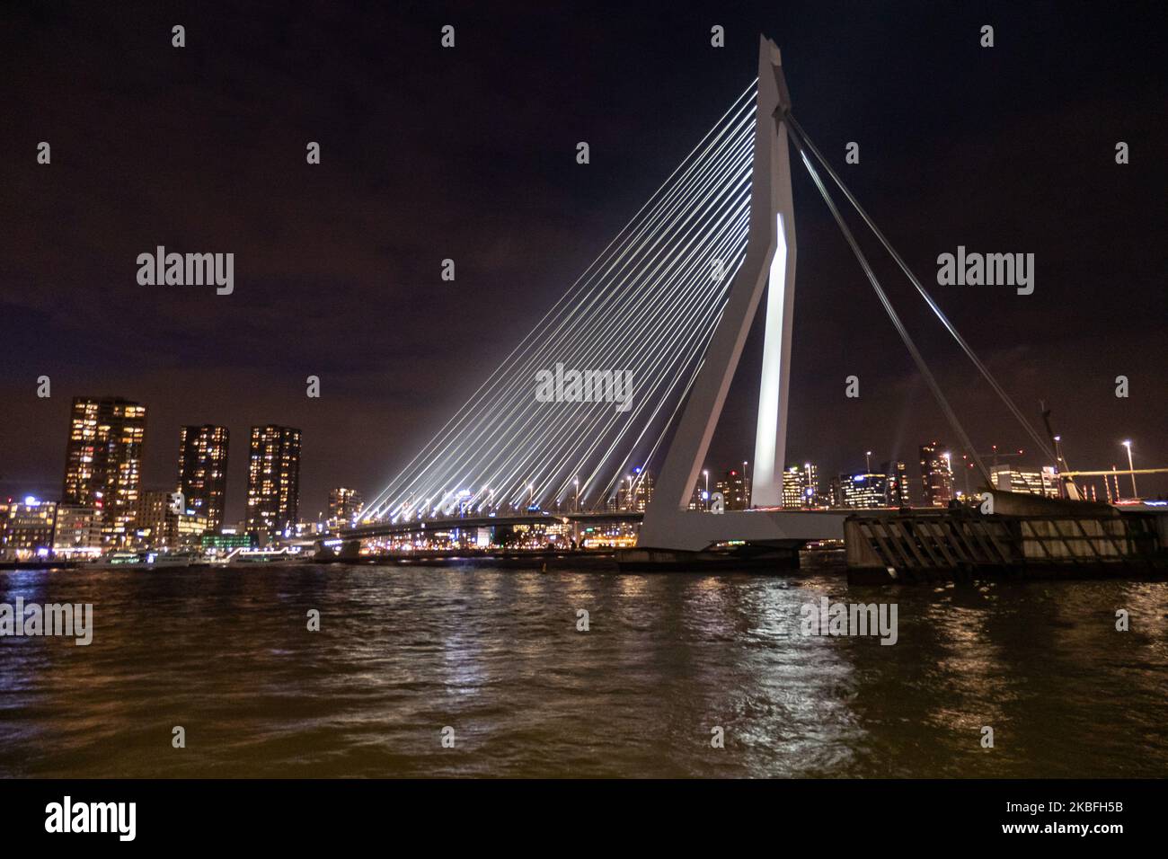 Erasmusbrug ou pont Erasmus vu illuminé dans la nuit dans le centre-ville de la ville néerlandaise, Rotterdam le 20 janvier 2020. Le long pont de 802m. Sur l'eau de la rivière New Meuse est un pont combiné à câbles et à bascules nommé d'après Desiderius Erasmus, conçu par Ben van Berkel. La construction et l'esturcture sont célèbres pour son architecture moderne et son design asymétrique de pylône bleu pâle ayant également le plus grand panneau de son type dans le monde. Le pont est un monument historique pour Rotterdam et les pays-Bas. (Photo de Nicolas Economou/NurPhoto) Banque D'Images