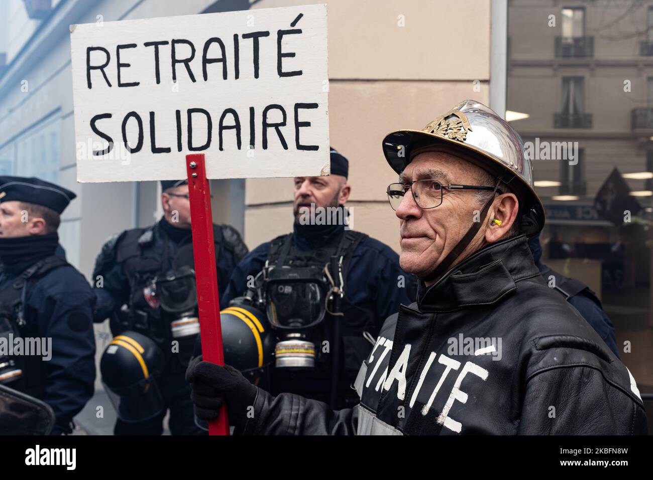 Un pompier tient un panneau sur lequel est inscrit "retraité en solidarité" ce mardi, 28 janvier 2020, à l'appel des syndicats professionnels des pompiers, Plusieurs milliers de pompiers ont manifesté à Paris entre la place de la République et la place de la Nation pour exiger la réévaluation de la prime au feu et leur retraite. Des affrontements avec la police ont éclaté le long de la procession et à la fin de la manifestation où quelques centaines de personnes ont essayé de briser un pont-bar, la police anti-émeutes a utilisé des gaz lacrymogènes et les GM2L nouvelles grenades pour les repousser. (Photo de Samuel Boivin/nu Banque D'Images