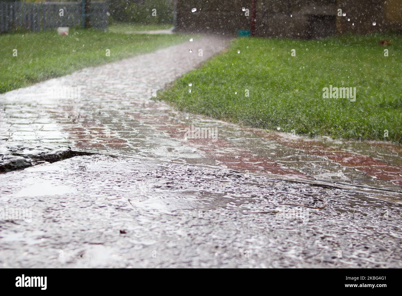 Une forte tempête dans la cour tombe sur le trottoir Banque D'Images
