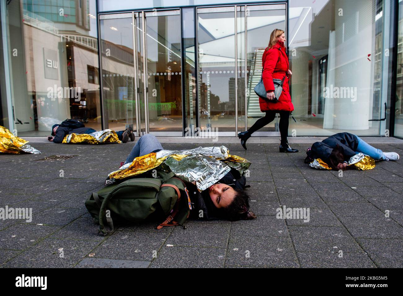 Un groupe de militants XR fait semblant de faire une fausse mort alors qu'une femme passe à Rotterdam sur 3 février 2020, lors de la troisième extinction de la rébellion Die in action. (Photo par Romy Arroyo Fernandez/NurPhoto) Banque D'Images