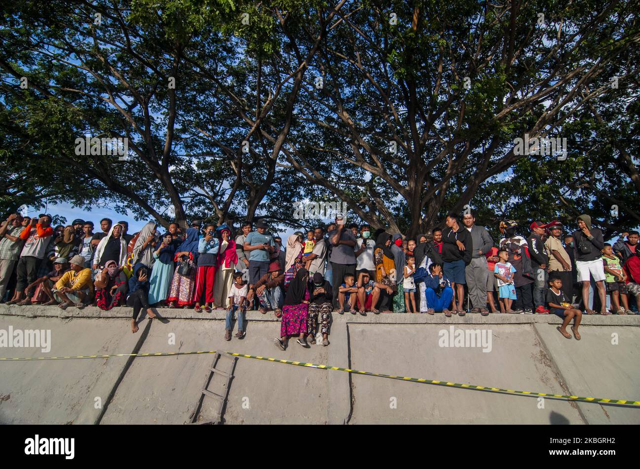 Les résidents observent les policiers qui tentent de capturer des crocodiles sauvages piégés dans des pneus usagés dans la rivière Palu, dans le centre de Sulawesi, en Indonésie, sur 11 février 2020. Le Natural Resources conservation Centre (BKSDA) a reçu l'aide des observateurs de la faune australienne Matthew Nicolas Wright et Chris Wilson pour libérer des pneus le premier qui a ensnared le crocodile sauvage depuis quatre ans. Depuis septembre 2018, plusieurs organisations amoureux de la faune ont tenté de sauver le pauvre crocodile, mais à ce jour rien n'a fonctionné. Les pneus usagés qui ont ensagué le cou du crocodile l'ont encore plus torturé à cause de Banque D'Images Les résidents observent les policiers qui tentent de capturer des crocodiles sauvages piégés dans des pneus usagés dans la rivière Palu, dans le centre de Sulawesi, en Indonésie, sur 11 février 2020. Le Natural Resources conservation Centre (BKSDA) a reçu l'aide des observateurs de la faune australienne Matthew Nicolas Wright et Chris Wilson pour libérer des pneus le premier qui a ensnared le crocodile sauvage depuis quatre ans. Depuis septembre 2018, plusieurs organisations amoureux de la faune ont tenté de sauver le pauvre crocodile, mais à ce jour rien n'a fonctionné. Les pneus usagés qui ont ensagué le cou du crocodile l'ont encore plus torturé à cause de Banque D'Images