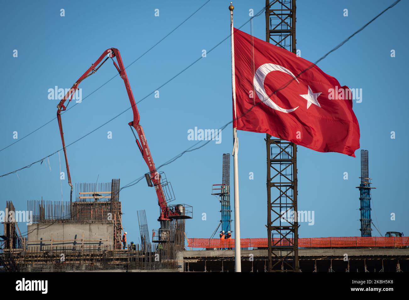 Un drapeau turc se déforme dans le vent tandis que les ouvriers de la construction ont posé la fondation et les murs de ciment du nouveau Centre culturel Ataturk pour les arts sur la place Taksim, la place centrale et l'espace urbain public d'Istanbul, Turquie sur 17 février 2020. (Photo de Diego Cupolo/NurPhoto) Banque D'Images